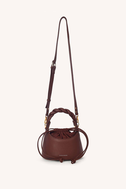 Brown leather handbag with a strap on a white background