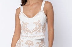 Woman wearing a white lace dress against a plain background