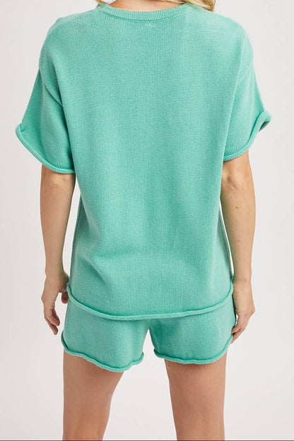 Woman wearing a teal pajama set on a plain background