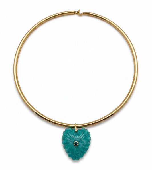 A gold-plated circular collar necklace featuring a textured, carved turquoise pendant with a small black eye detail in the center, shown against a plain white background.