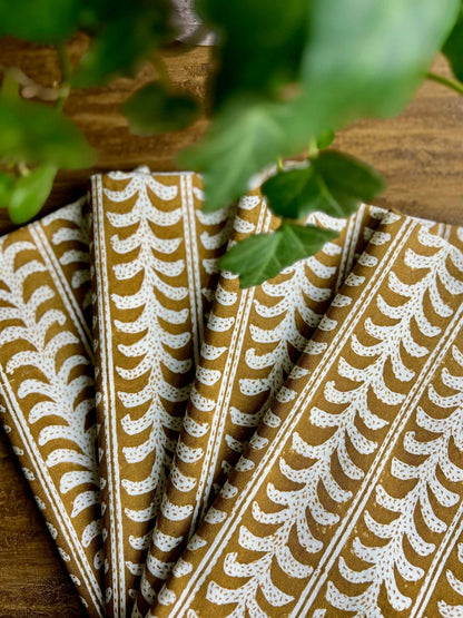 Folded fabric with a leaf pattern on a wooden surface