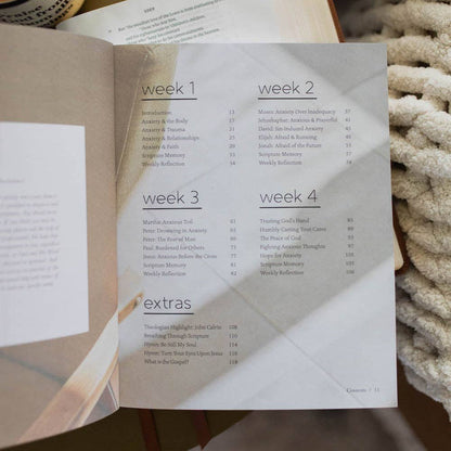 Open book showing a table of contents with weeks 1 to 4 and extras.