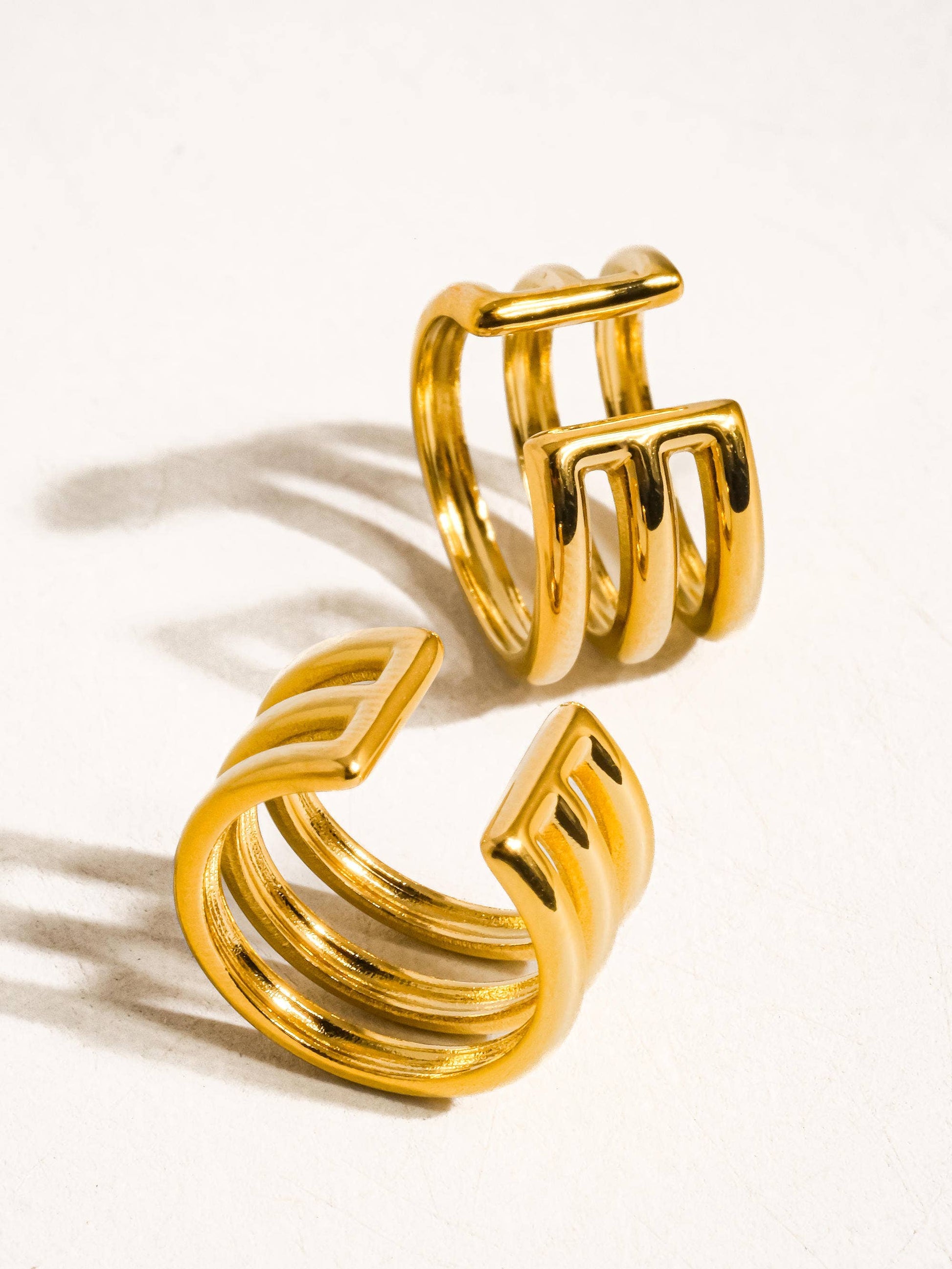 Pair of gold hoop ear cuffs on a white background