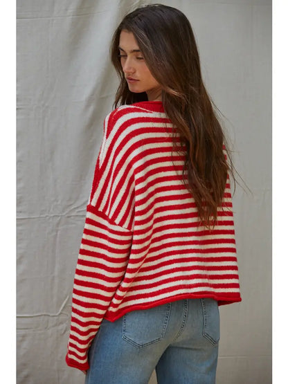Person wearing a red and white striped sweater against a plain background