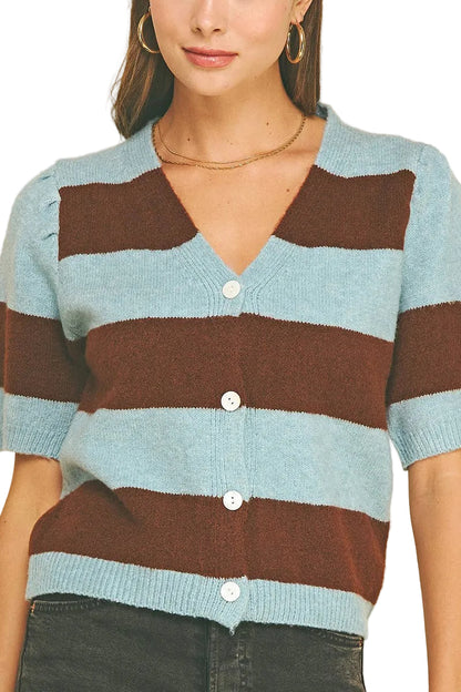 A woman wearing a short-sleeve knit cardigan with horizontal stripes in light blue and dark brown, featuring a V-neck and white buttons, set against a solid white background.