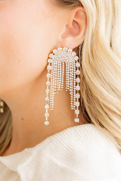 Close-up of a person wearing a sparkling earring with dangling beads.