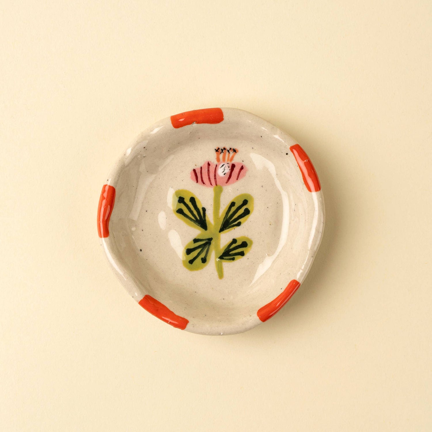 Ceramic dish with floral design on a beige background