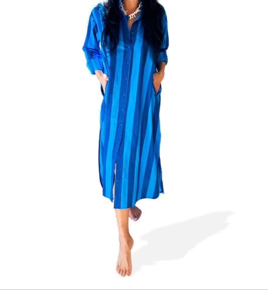 Woman wearing a blue striped dress and cap on a white background