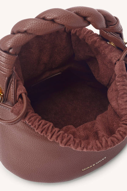 Brown braided handbag with visible brand name on a white background