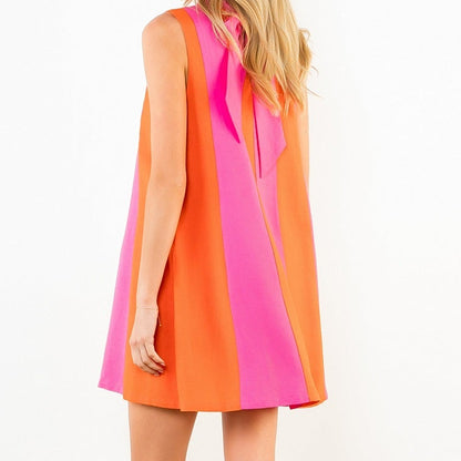 Woman wearing a colorful dress with a plain background