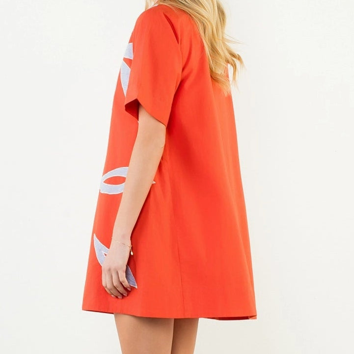 Woman wearing a bright orange dress on a white background