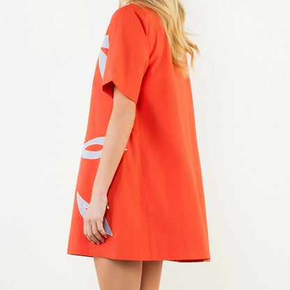 Woman wearing a bright orange dress on a white background