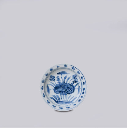 Blue and white ceramic plate with floral design on a light gray background