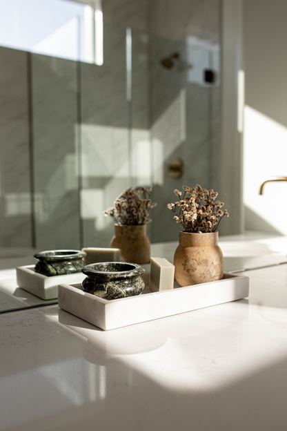 Decorative items on a white surface with a reflective background