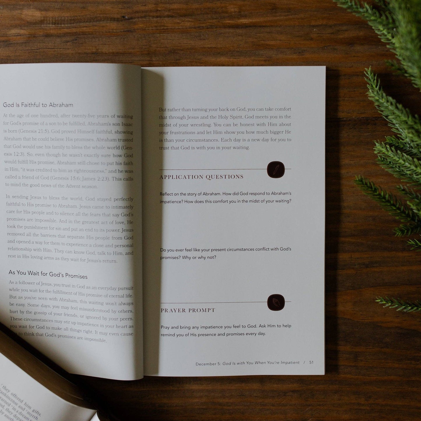 Open book with text and questions on a wooden surface with greenery