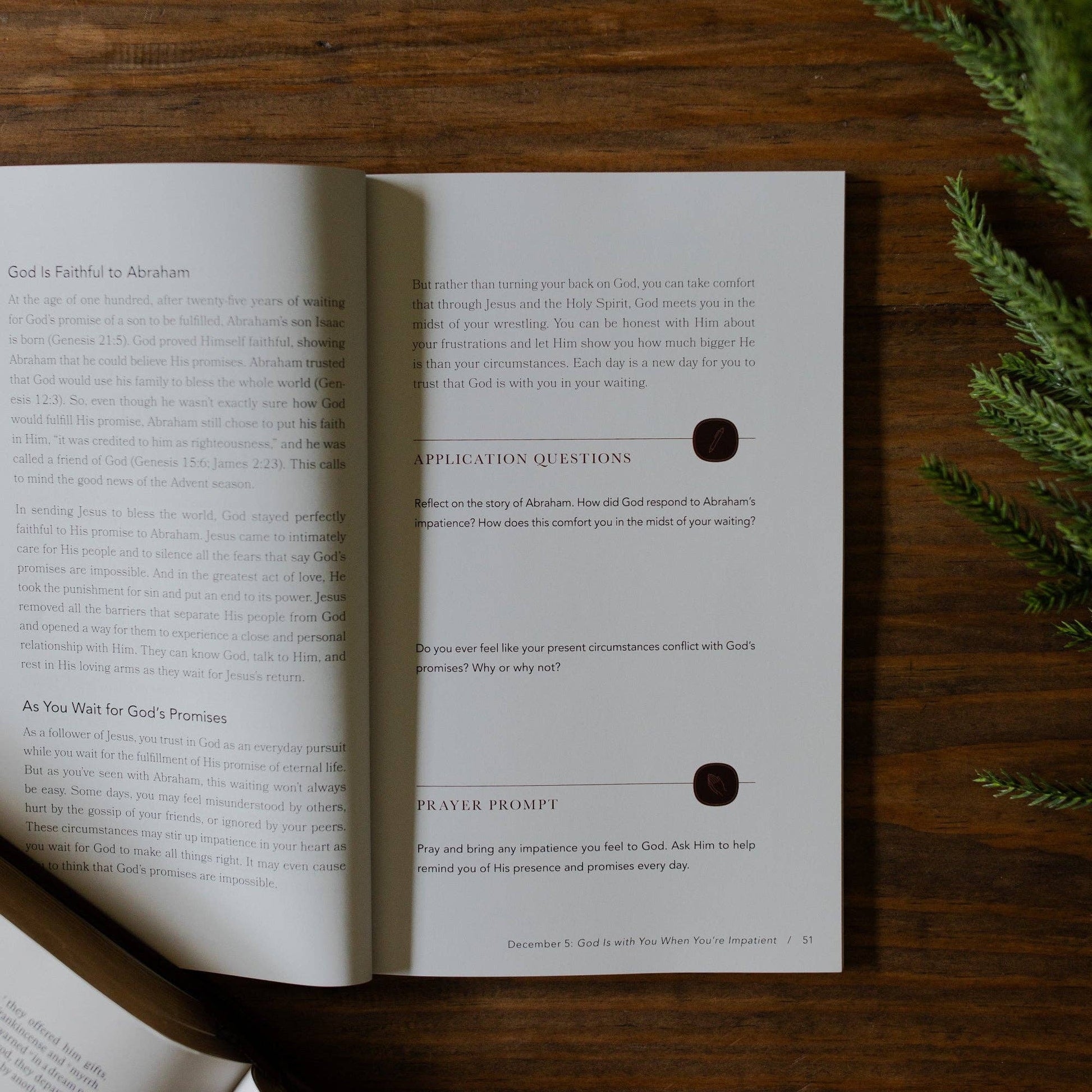 Open book with text and questions on a wooden surface with greenery