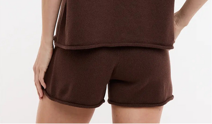 Woman wearing a brown t-shirt and shorts set on a white background