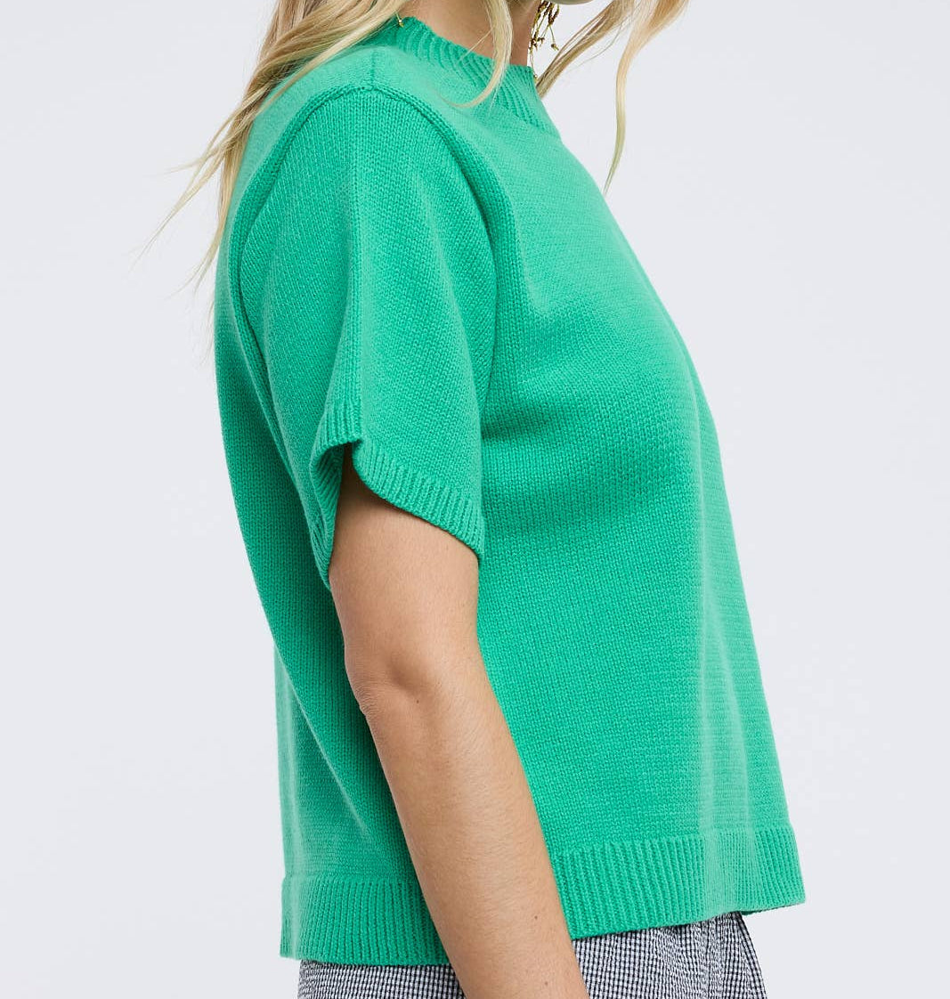 Woman wearing a green sweater against a white background