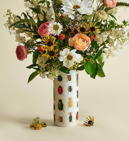 Bouquet of flowers in a vase with beetle pattern on a beige background