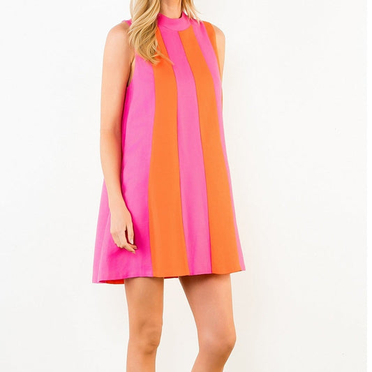 Woman wearing a colorful dress with pink and orange stripes on a white background