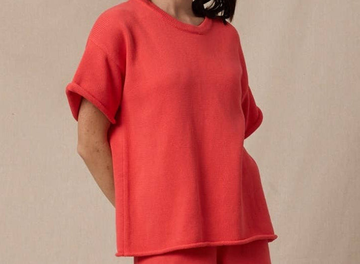 Woman wearing a red outfit against a beige background