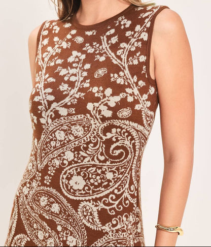 A woman wearing a sleeveless brown knit top with a cream paisley and floral pattern, shown against a plain light background.