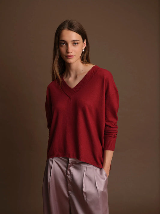 Woman wearing a red sweater against a brown background