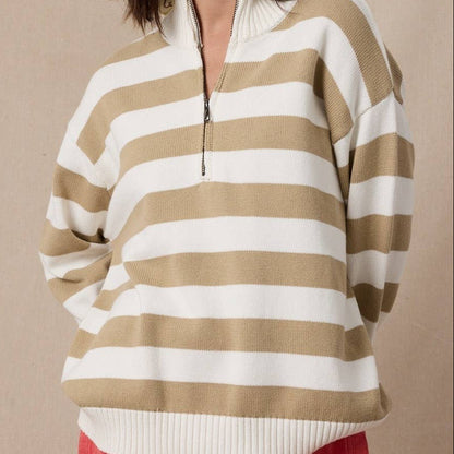 Woman wearing a beige and white striped sweater against a beige background