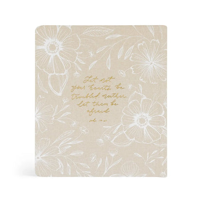 Beige notebook with floral patterns and text on a white background