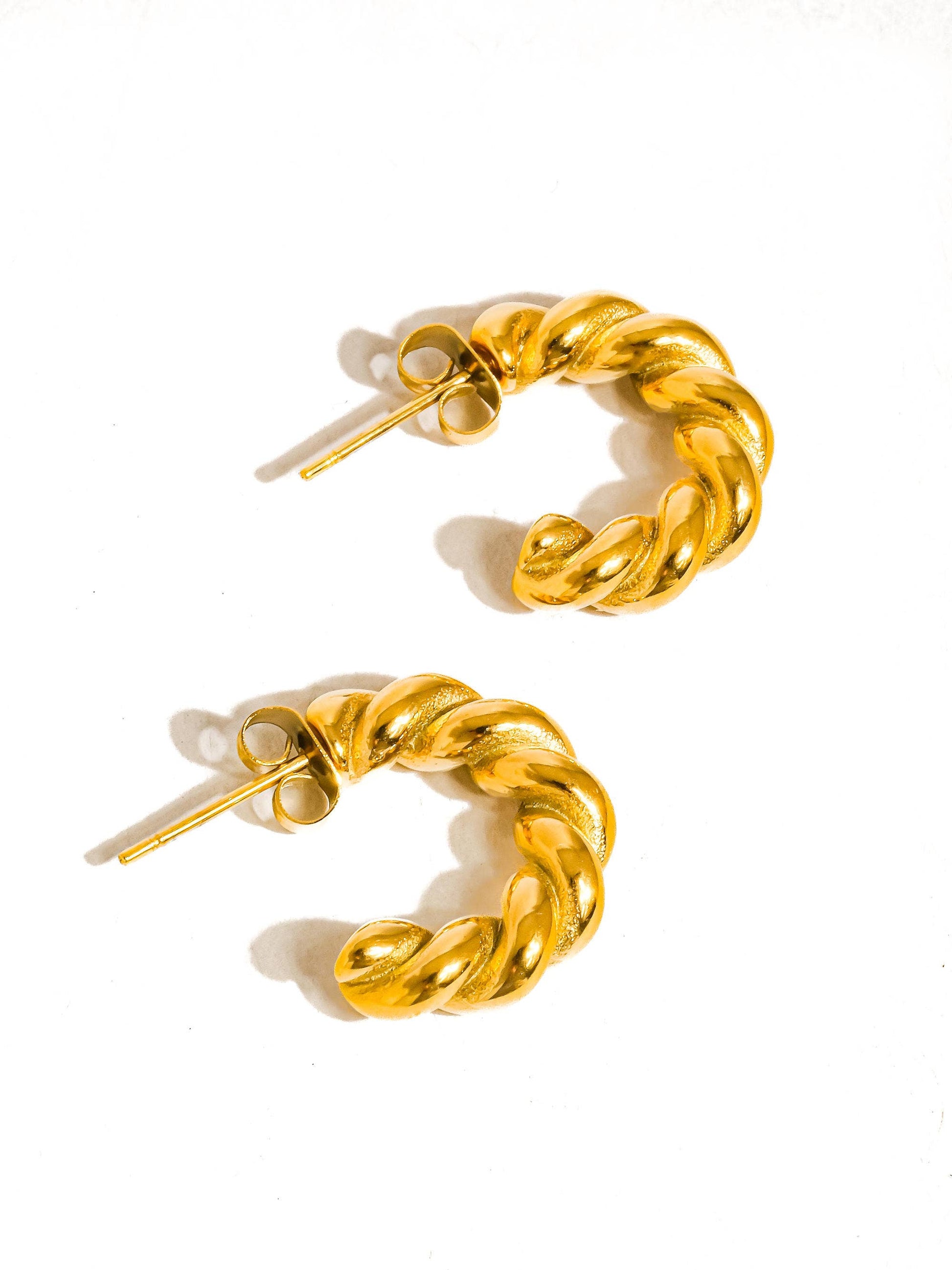 Gold chain hoop earrings on a white background