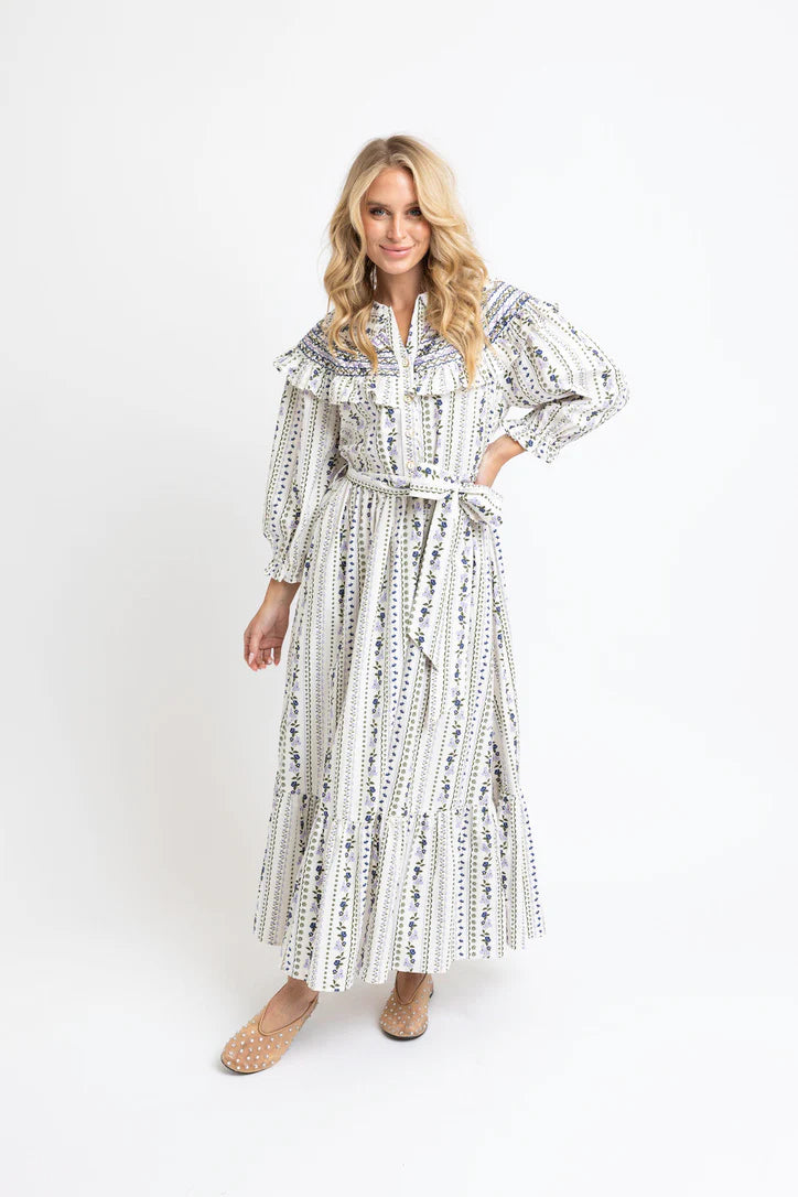 Woman wearing a long, patterned dress on a white background