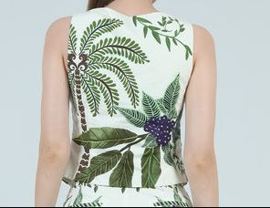 Woman wearing a sleeveless top and shorts with a floral pattern on a plain background