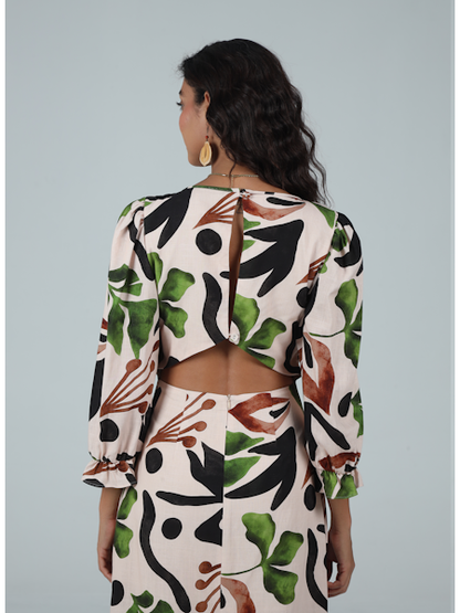 Woman wearing a floral patterned outfit on a plain background