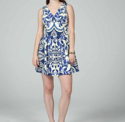 Woman wearing a blue and white patterned dress on a gray background