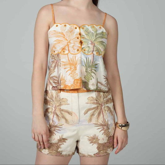 Woman wearing a floral top and shorts on a gray background