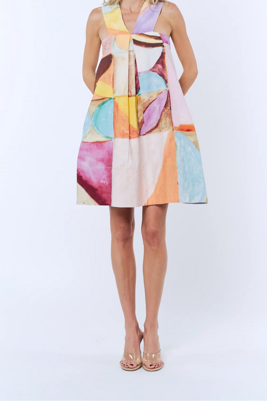 Woman wearing a colorful abstract patterned dress on a white background