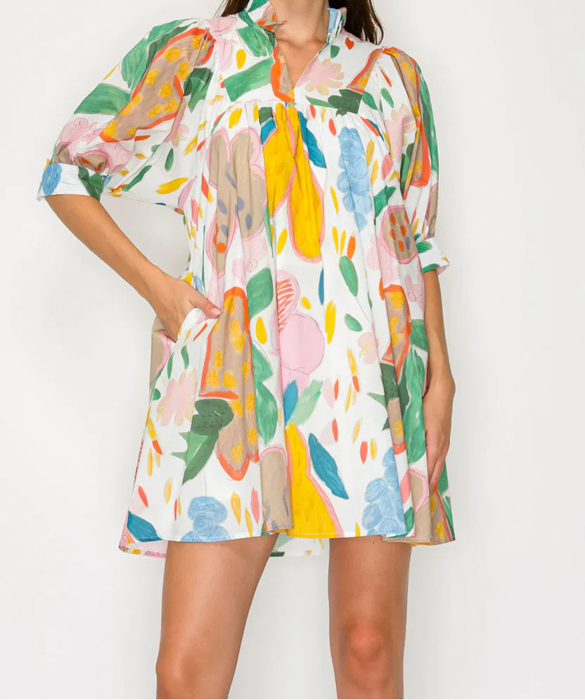 Woman wearing a colorful floral dress against a white background