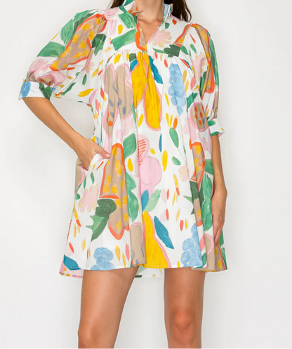 Woman wearing a colorful floral dress against a white background