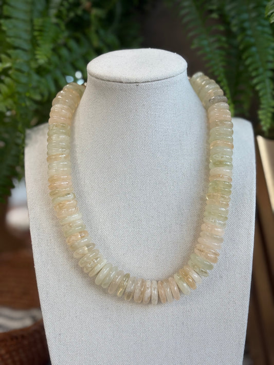 Necklace with round beads on a jewelry display  with a natural background.