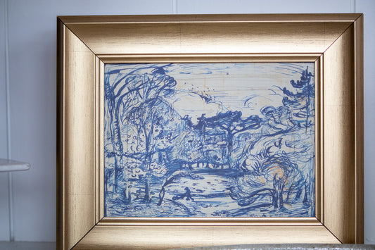 Framed artwork with blue landscape design on a white wall