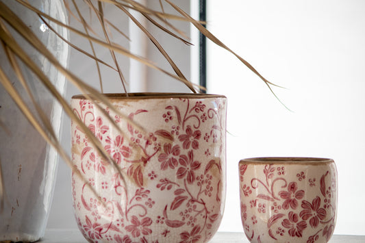 Two ceramic pots with floral patterns on a light background