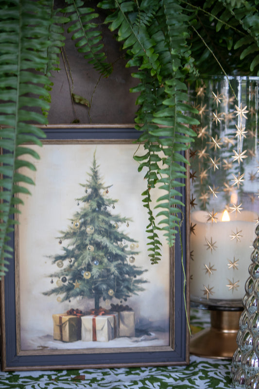 Framed Christmas tree print with decorative candle and greenery