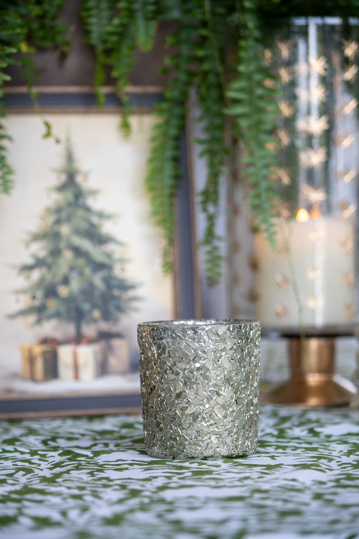Decorative candle on a table with a blurred festive background