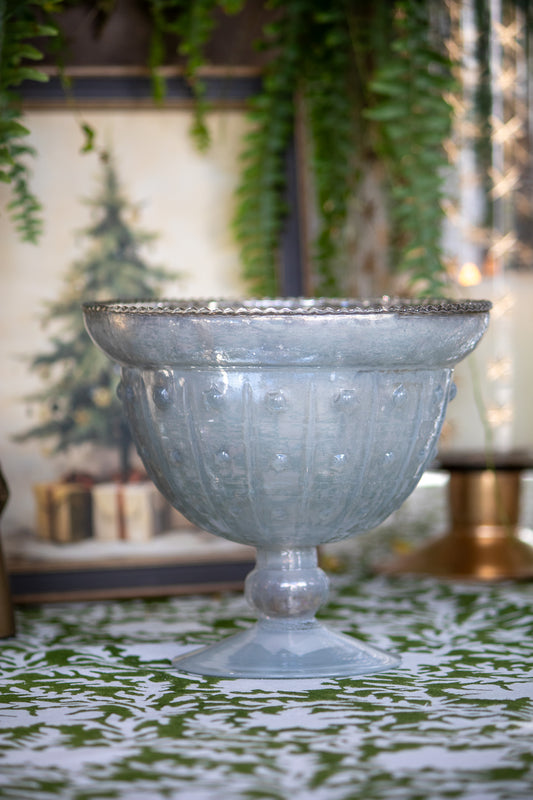 Decorative glass bowl on a patterned surface with blurred background