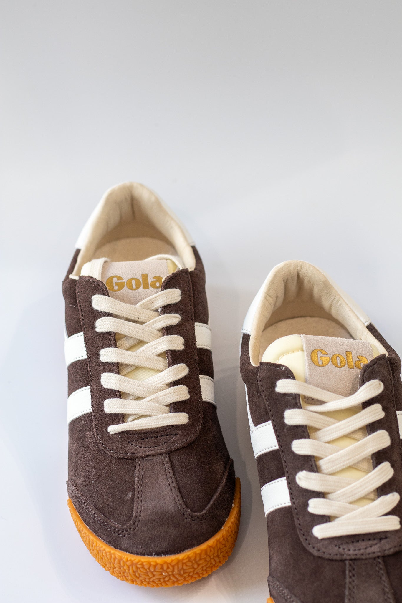 Pair of Gola sneakers with white laces on a light gray background