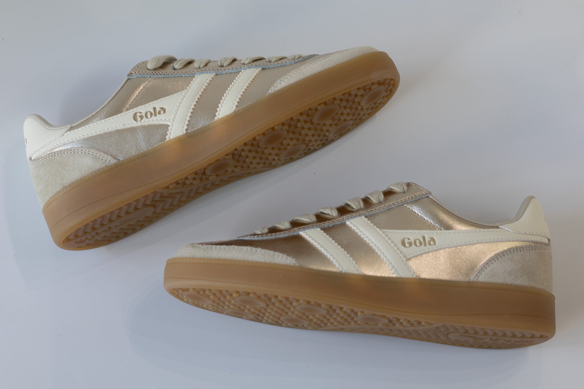 Pair of beige sneakers with brown soles on a white background