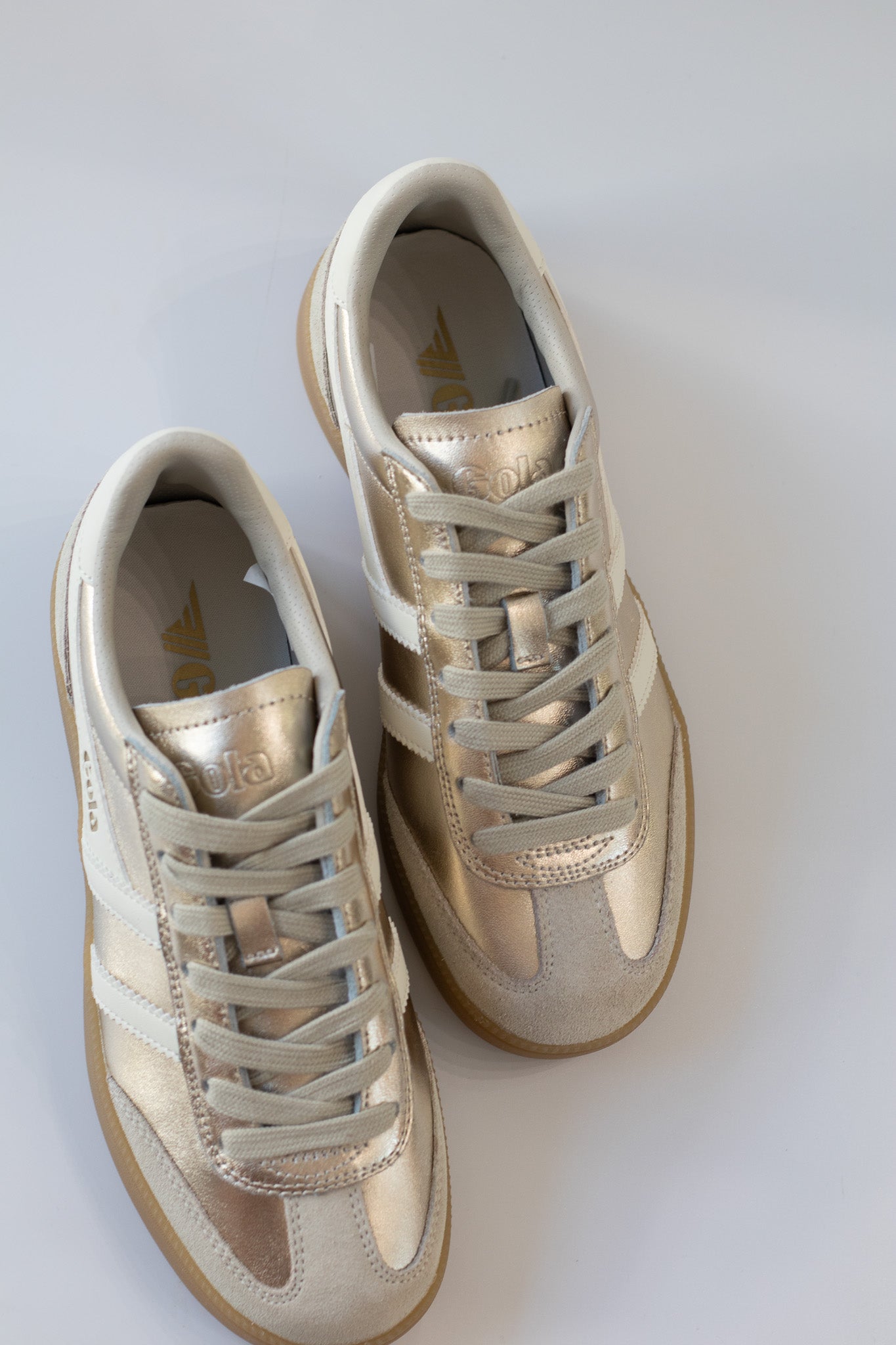 Pair of beige sneakers on a white background