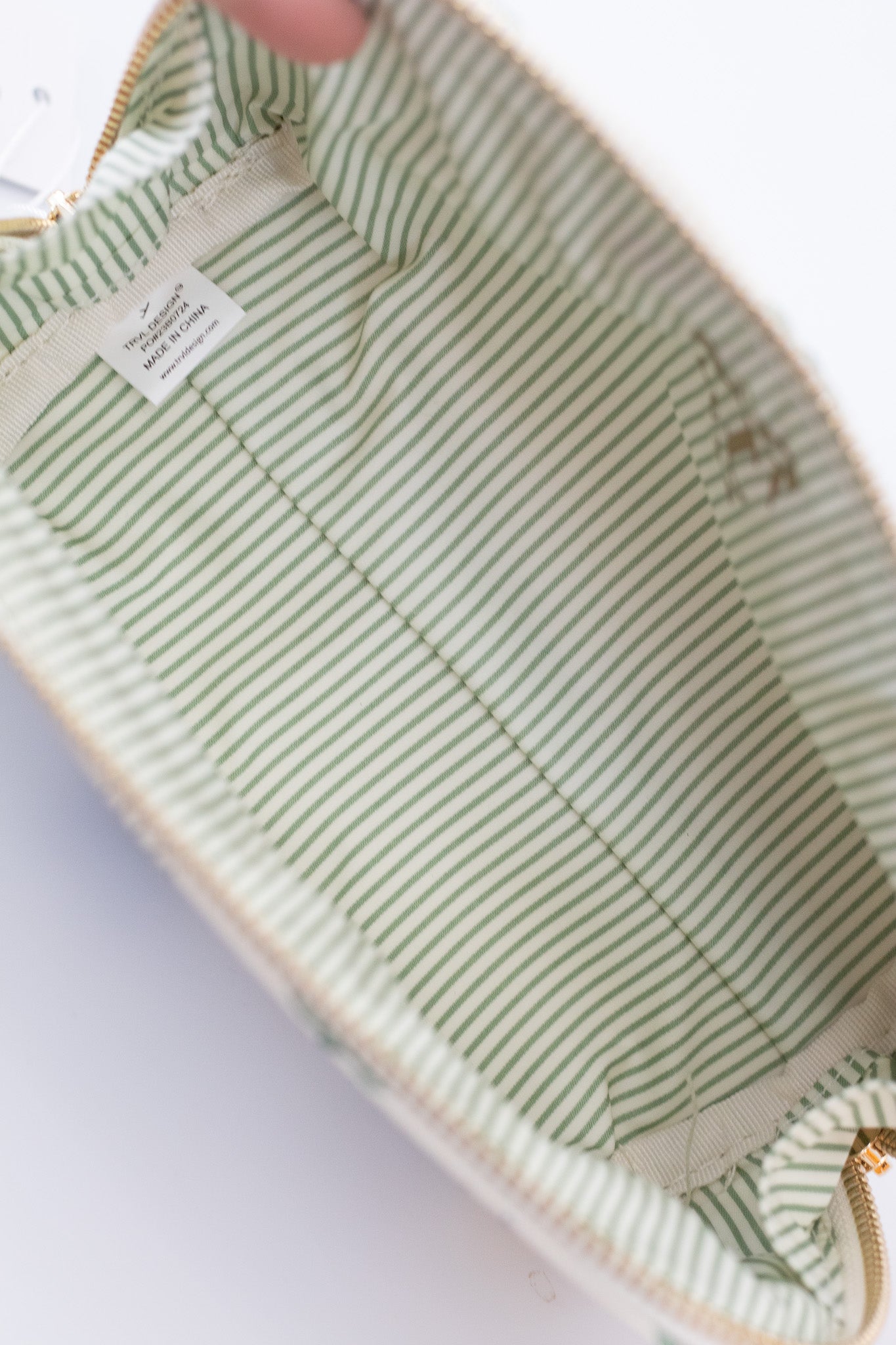 Green and white striped baby outfit with a visible brand label on a light background