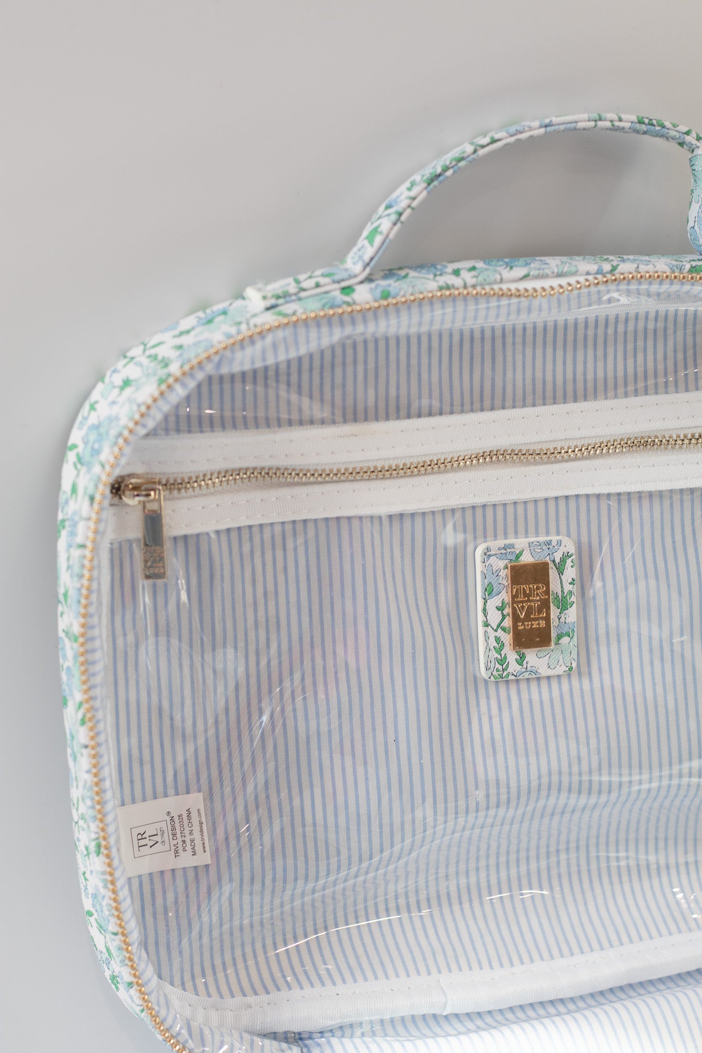 Clear plastic bag with floral border and striped interior on a light gray background