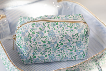 Floral-patterned toiletry bag inside an open suitcase